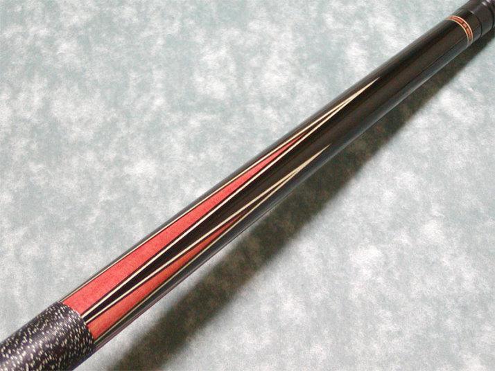 A billiard cue with red ivory inlay.