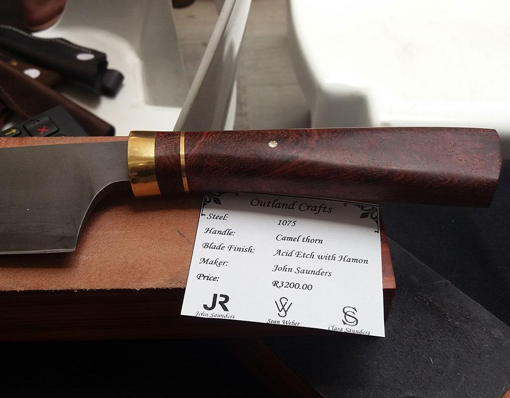 A handcrafted knife handle made from camel thorn hardwood by John Saunders.